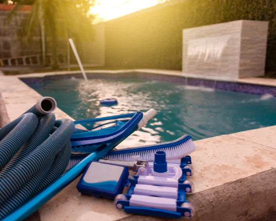 Pool cleaning tools on a poolside with a pool in the background